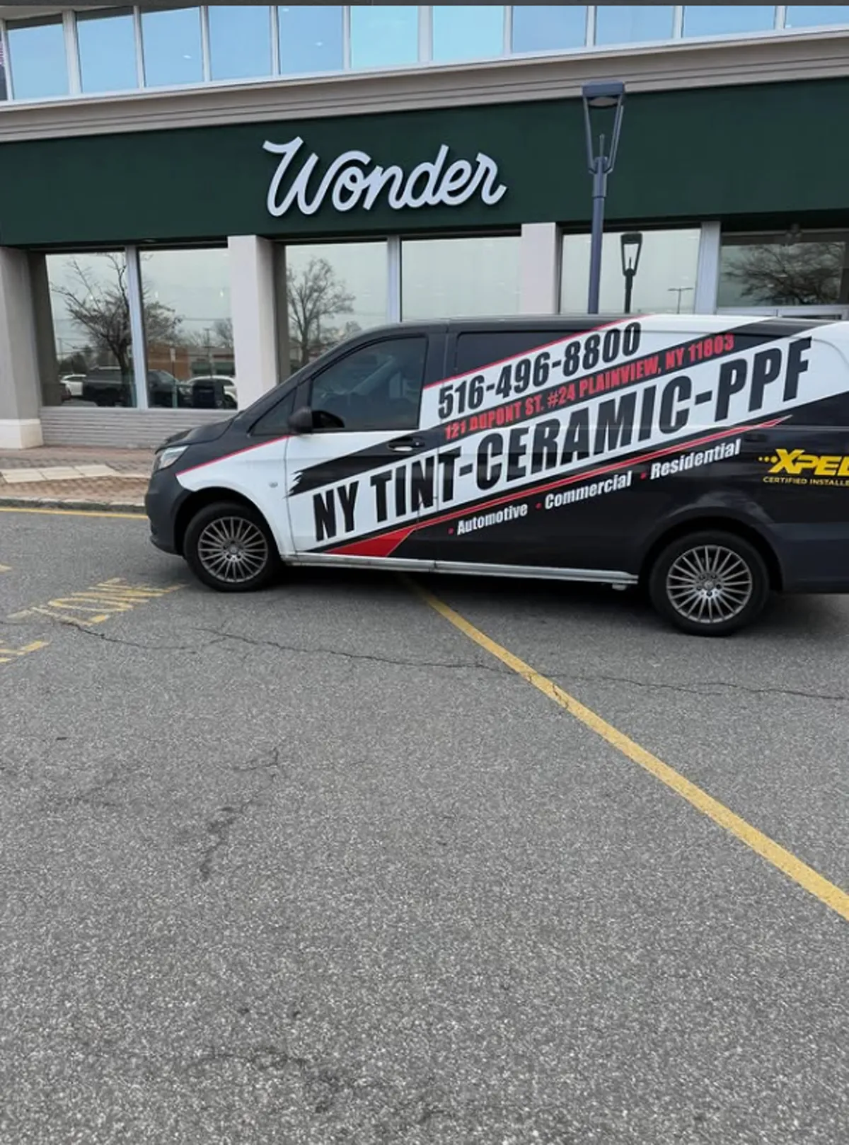 NY Window Tinting branded van parked outside the Wonder retail storefront on Long Island