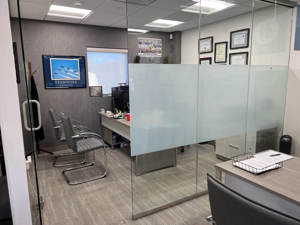 Private office with frosted glass partition and certificates on the wall