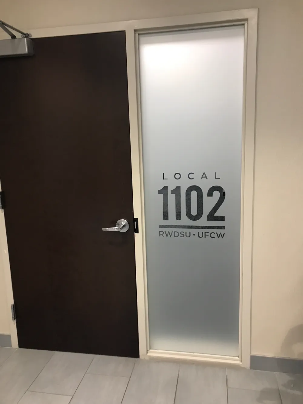 Union office entry door with frosted privacy film strip across the glass